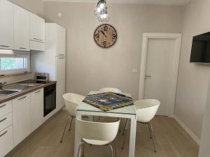 a kitchen with a table with chairs and a clock on the wall at VILLA BORGHESE in Racalmuto