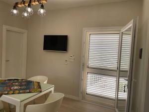 a dining room with a table and chairs and a television at VILLA BORGHESE in Racalmuto