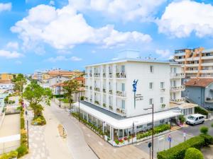 una strada cittadina con un edificio bianco di Hb Hotels Orchidea Blu a Rimini