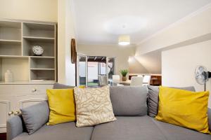 ein Wohnzimmer mit einem grauen Sofa und gelben Kissen in der Unterkunft Penthouse Vista Mar in Funchal