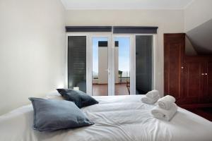 a white bed with two pillows and towels on it at Penthouse Vista Mar in Funchal