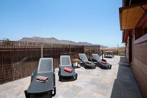 a row of chaise lounge chairs on a patio at La Casita de Vidal in Tuineje