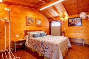a bedroom with a bed in a wooden cabin at La Casita de Vidal in Tuineje