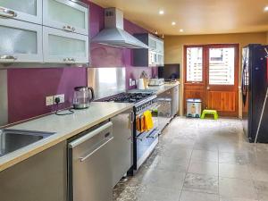 a kitchen with stainless steel appliances and purple walls at Coach House in Ashford