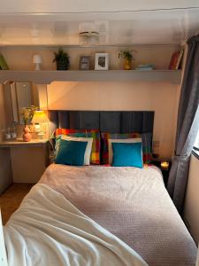 ein Schlafzimmer mit einem großen Bett und blauen Kissen in der Unterkunft Domki na Kwiatowej Okuninka - Orchówek in Orchówek
