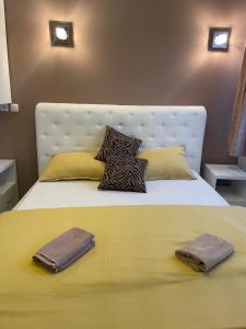 a bed with two pillows and two towels on it at Apartmani Kotor Varoš in Donja Varoš