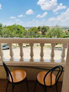 two chairs on a balcony with a view of a street at Ballestar Hotel Bar & Grill in Barajas de Melo