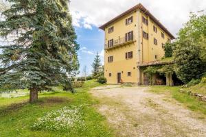 an external view of a large yellow building at Villa Sanguigni in Bagnolo