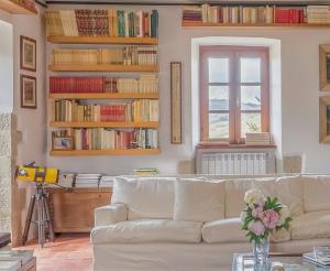a living room with a white couch and bookshelves at Villa Sanguigni in Bagnolo