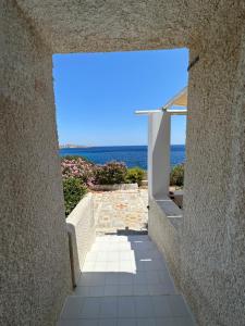 a view of the ocean from a stone walkway at Villa Mavromichali private beach in Liaropá