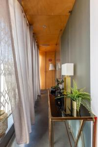 einen Flur mit Vorhängen und einem Tisch mit einer Lampe in der Unterkunft Hostel & cia in Porto