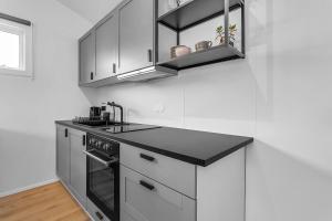 a kitchen with white cabinets and a black counter top at Cozy Haven in Hafnarfjörður in Hafnarfjörður