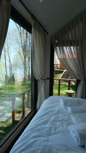 a bedroom with a bed and a large window at MANZARA SUİTES ORMAN KÖY in Kartepe