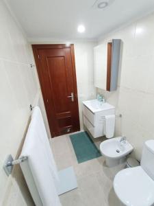 a white bathroom with a toilet and a sink at Apartamento Idaira Sun in Los Cristianos +2 photos