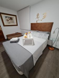 una camera da letto con un grande letto con un tavolo sopra di Casa Ramirez a Málaga