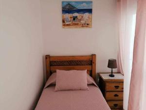 ein Schlafzimmer mit einem Bett und einem Bild an der Wand in der Unterkunft DieAna II Alojamento Vila Viçosa in Vila Viçosa
