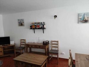 Habitación con mesa, sillas y estante con botellas. en DieAna II Alojamento Vila Viçosa en Vila Viçosa