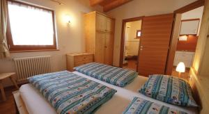 a bedroom with two beds and a window at Apartments Antersi Silvia in San Vigilio Di Marebbe