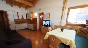 a living room with a table and a tv at Apartments Antersi Silvia in San Vigilio Di Marebbe