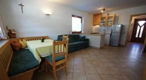 a kitchen and living room with a table and a couch at Apartments Antersi Claudia in San Vigilio Di Marebbe
