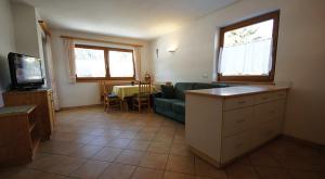 a living room with a green couch and a table at Apartments Antersi Claudia in San Vigilio Di Marebbe