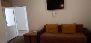 sala de estar con sofá y TV en la pared en Casa Class, en Băile Felix