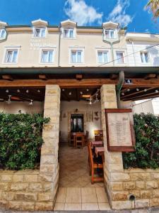 ein Hotel mit einem Gebäude im Hintergrund in der Unterkunft Villa Palčić II in Novalja