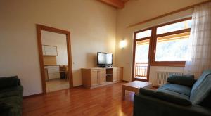 a living room with a couch and a tv at Apartments Antersi Robbi in San Vigilio Di Marebbe