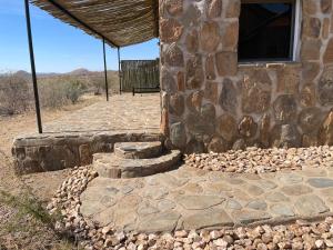 un edificio de piedra con un banco delante en Düsternbrook Guest Farm, en Dusternbrook