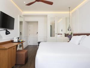 a bedroom with a large bed and a flat screen tv at H10 Universitat in Barcelona