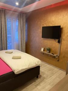 a bedroom with a bed and a flat screen tv at Apartmani Kotor Varoš in Donja Varoš
