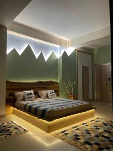 um quarto com uma cama com montanhas pintadas na parede em Amara Luxury B&B em Tirana
