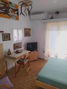 Habitación con mesa y dormitorio con cama. en Beautiful Cottage over-viewing Samos bay., en Samos