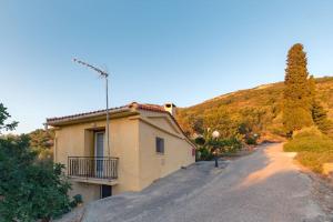 una casa en un camino al lado de una montaña en Beautiful Cottage over-viewing Samos bay., en Samos