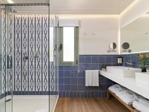 a bathroom with blue tiles and a shower at H10 Universitat in Barcelona