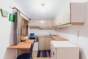 a small kitchen with white cabinets and a table at Beautiful Cottage over-viewing Samos bay. in Samos