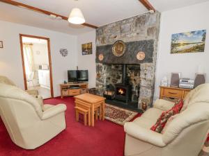 a living room with two chairs and a fireplace at Bodalaw in Trawsfynydd