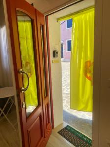 an open door with a yellow curtain in a room at Casa Bella in Burano