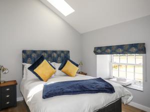 um quarto com uma cama com almofadas amarelas e azuis em The Forge em Holyhead