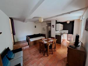 a living room with a table and a kitchen at Appart-Hôtel Résidence Maloc in Malaucène