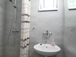 W łazience znajduje się biała umywalka i prysznic. w obiekcie Camping Rožnov w mieście Rožnov pod Radhoštěm