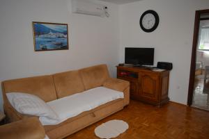 a living room with a couch and a tv at Apartment Dragica in Kornić