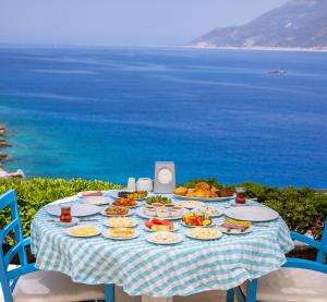 - une table avec des assiettes de nourriture au-dessus de l'océan dans l'établissement Arpia Hotel, à Kaş