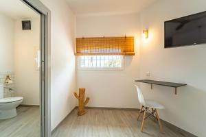 a bathroom with a toilet and a television on the wall at Calas De Meca in Los Caños de Meca