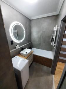 a bathroom with a sink and a toilet and a mirror at Apartament Nowa letnica in Gdańsk