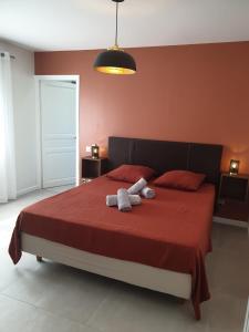 a bedroom with a red bed with two towels on it at Villa Lumie - Superbe villa pour 8 personnes entièrement rénovée en 2023 avec piscine privée in Sainte-Maxime +28 photos