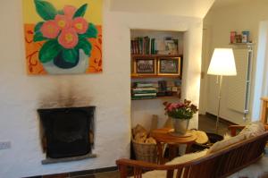 a living room with a fireplace with a flower painting on the wall at Beaufort Lodge B&B & Cottage in Beaufort