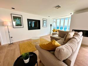a living room with a couch and a tv at Stunning Panoramic Sea View Beach Location - Sleeps up to 4 People - Free Parking - The Best Beach! - Great Location - Fast WiFi - Smart TV - Newly decorated - sleeps up to 4! Close to Bournemouth & Poole Town Centre & Sandbanks in Bournemouth