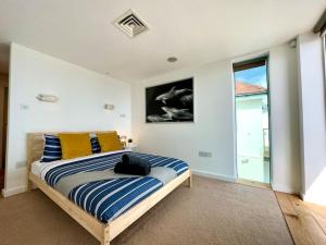 a bedroom with a bed with blue and yellow pillows at Stunning Panoramic Sea View Beach Location - Sleeps up to 4 People - Free Parking - The Best Beach! - Great Location - Fast WiFi - Smart TV - Newly decorated - sleeps up to 4! Close to Bournemouth & Poole Town Centre & Sandbanks in Bournemouth
