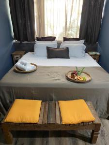 uma cama grande com uma bandeja de comida em Pousada Pé na Areia em Abraão
